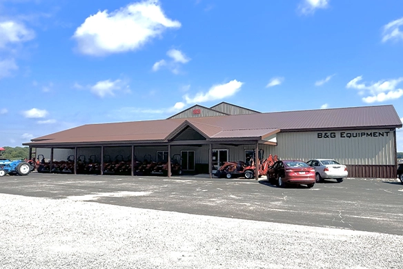 Exterior view of B&G Equipment dealership with tractors displayed and parking area