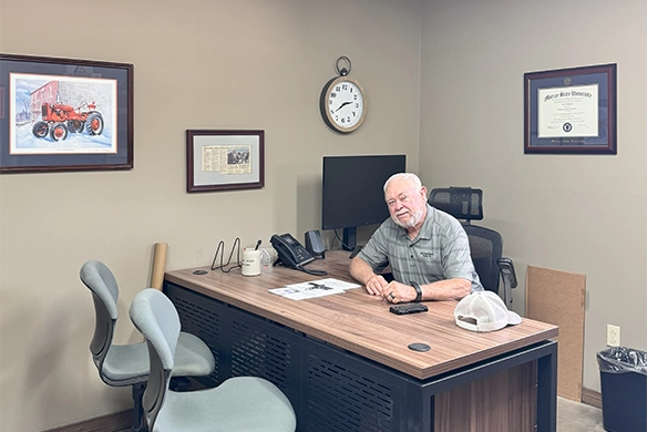 B&G Equipment office manager sitting at his desk in a modern farm dealership office